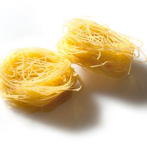 Italian raw pasta, angel hair type, on white